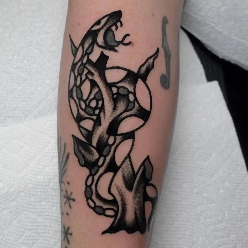 a snake on a branch tattoo