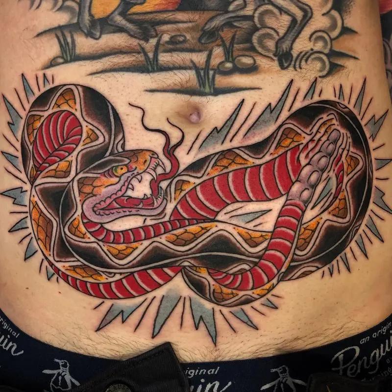 a tattoo of a snake on a stomach