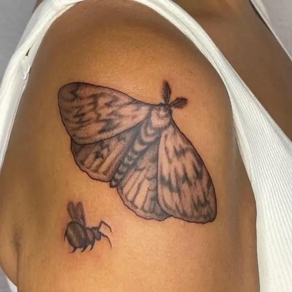 a tattoo of a insects on a person's shoulder