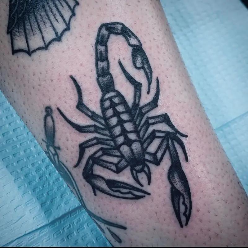 a scorpion tattoo at the arm