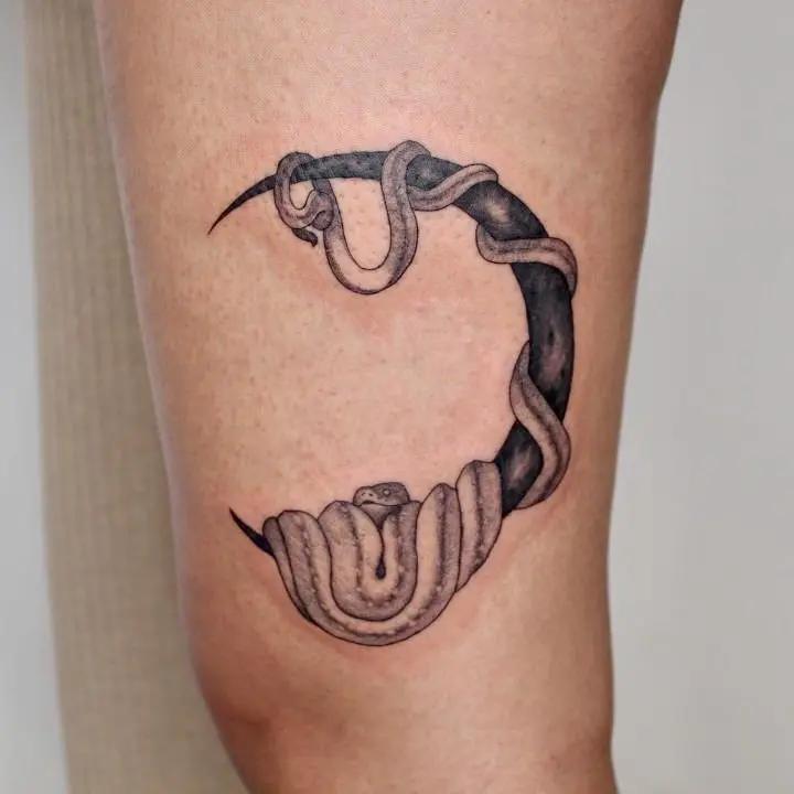 a tattoo of a snake on a person's leg