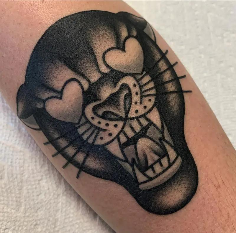 a tattoo of a panther with hearts on it