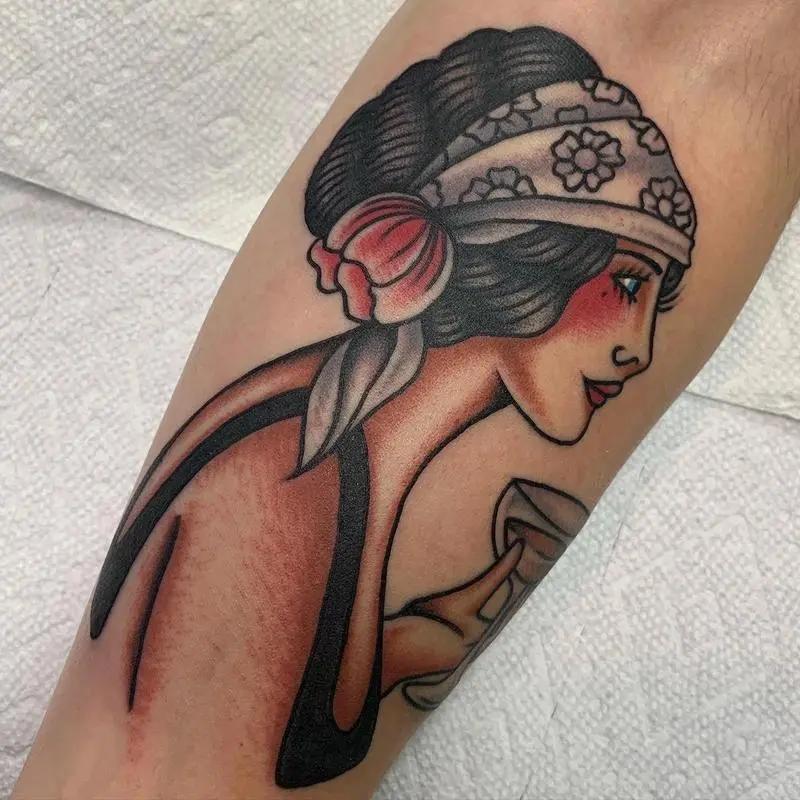 a tattoo of a woman holding a glass