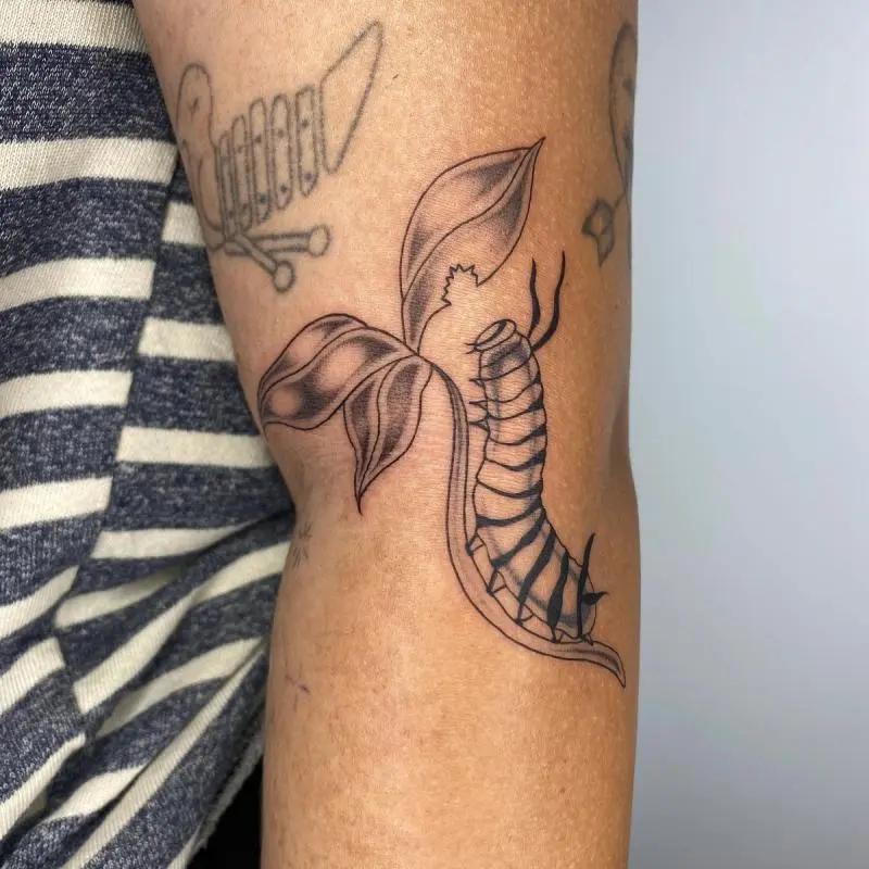 a caterpillar tattoo on a person's arm